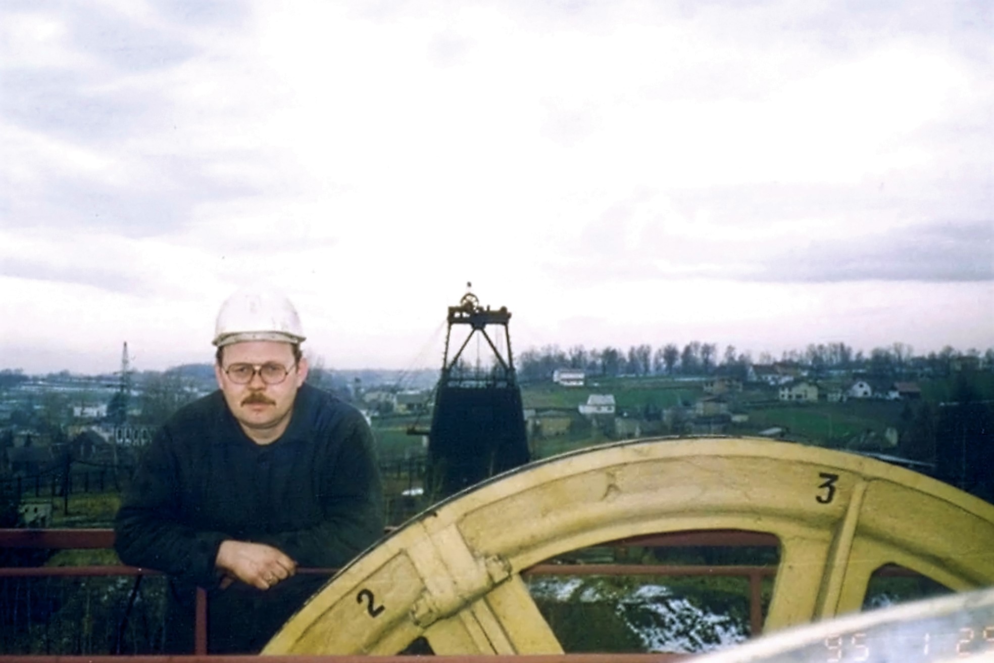 Widok z szybu V na szyb VII. W tle panorama Krostoszowic. Na zdjęciu nieznany pracownik, Zdjęcie wykonano prawdopodobnie w 1995 r.